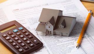 Picture of midel house and calculator on top of a spreadsheet