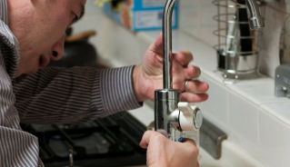 Man installing new kitchen faucet