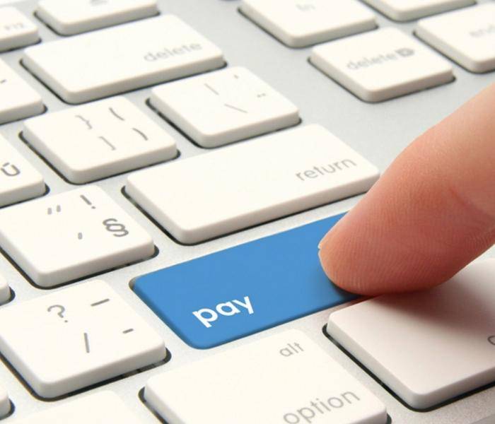 Picture of finger on computer keyboard press pay button