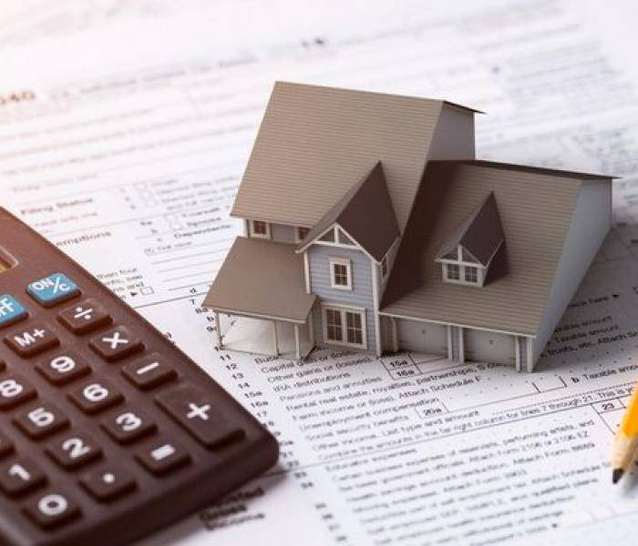 Picture of midel house and calculator on top of a spreadsheet